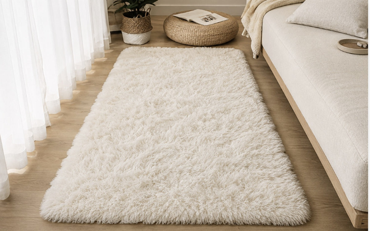 Aveline Plush Rug laid out next to a low sofa, seen from the side